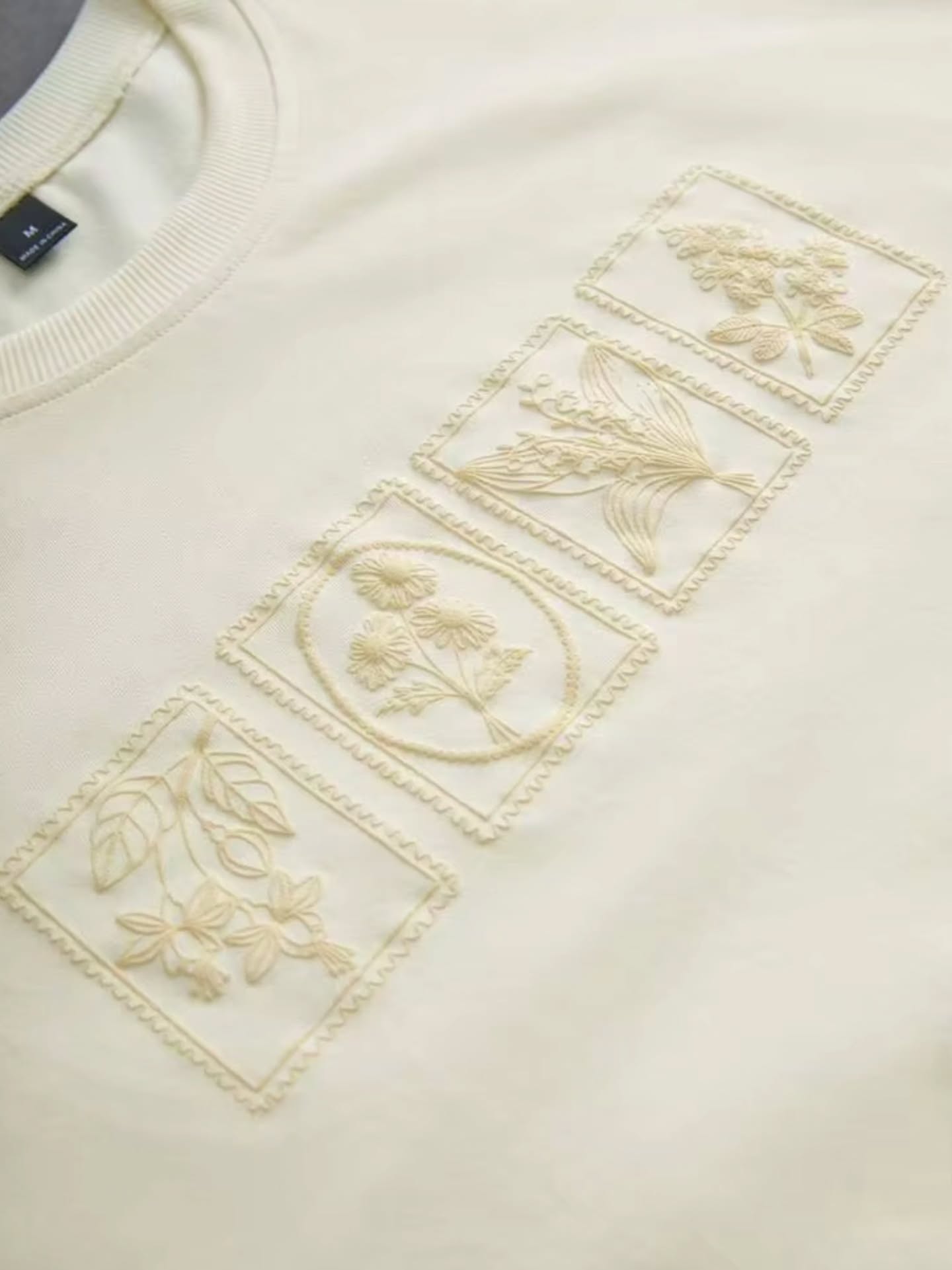 off-white / cream short-sleeved t-shirt with a subtle