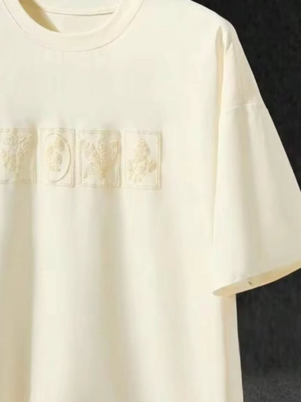 off-white / cream short-sleeved t-shirt with a subtle