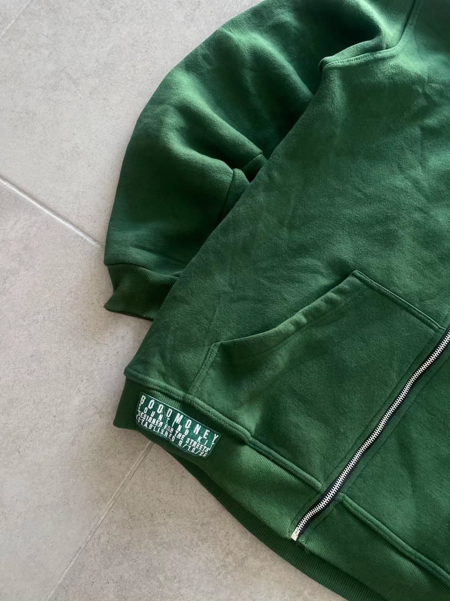 forest green full-zip hoodie (a "full-face zip" style) loaded with heavy, edgy Y2K/streetwear graphics and bold skull motifs