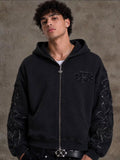 faded washed-black full-zip hoodie featuring heavy raw-edge applique patches and contrast embroidery