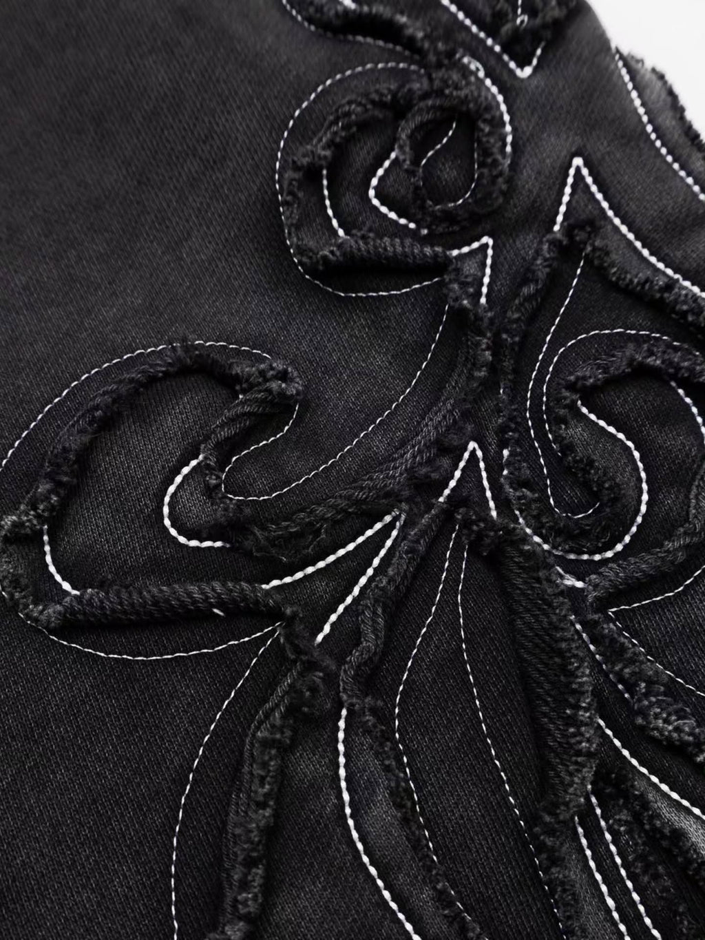 faded washed-black full-zip hoodie featuring heavy raw-edge applique patches and contrast embroidery