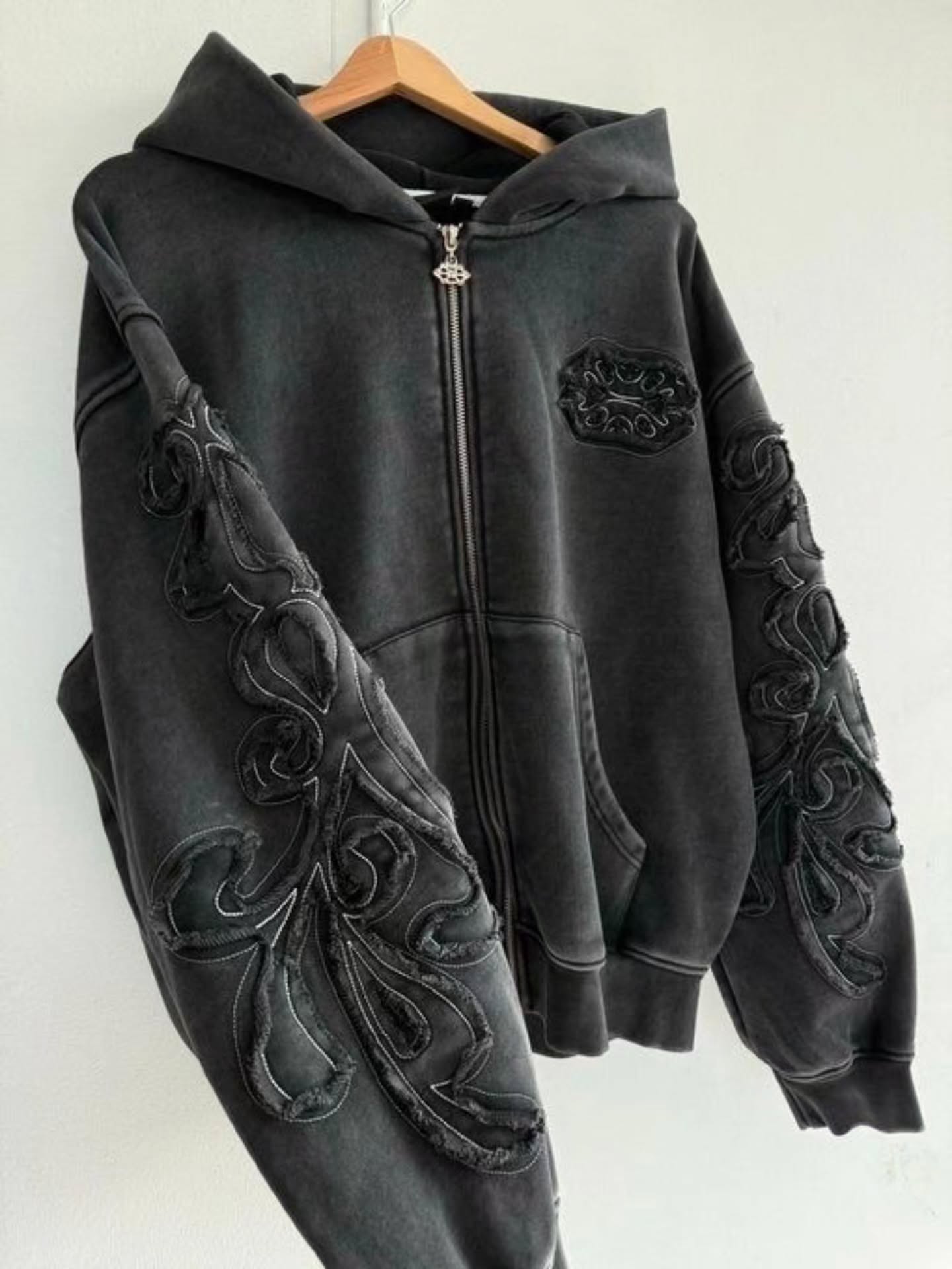 faded washed-black full-zip hoodie featuring heavy raw-edge applique patches and contrast embroidery