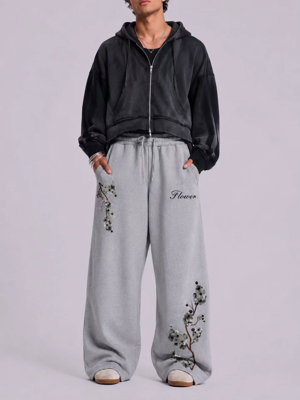 boxy, oversized streetwear outfit pairing a cropped acid-washed zip hoodie with wide-leg graphic sweatpants for a relaxed, Y2K-inspired silhouette.