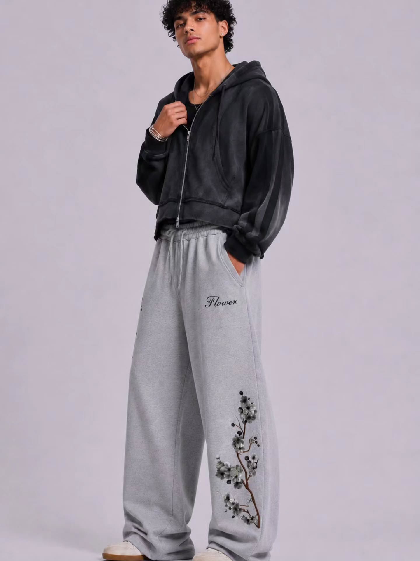 boxy, oversized streetwear outfit pairing a cropped acid-washed zip hoodie with wide-leg graphic sweatpants for a relaxed, Y2K-inspired silhouette.